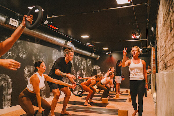 woman teaching team with weights